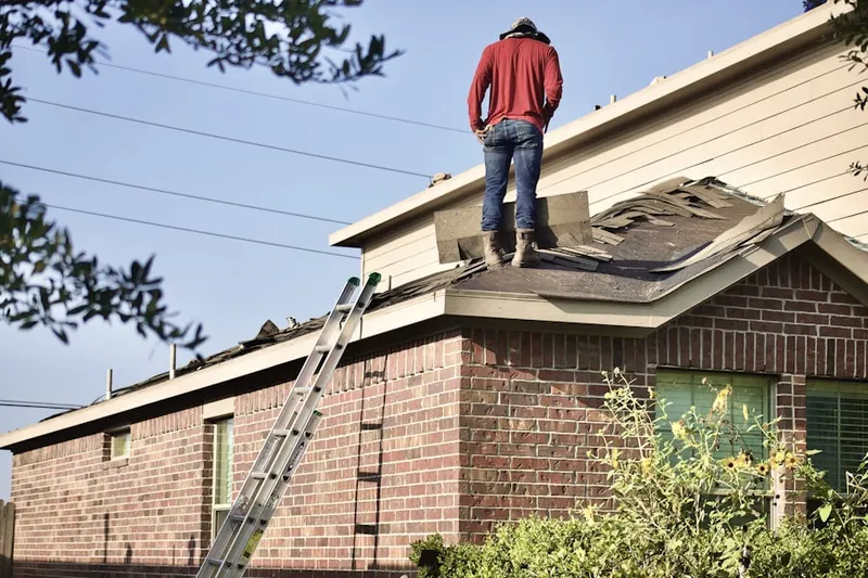Professional roofer working on a residential roof in Gurleyville